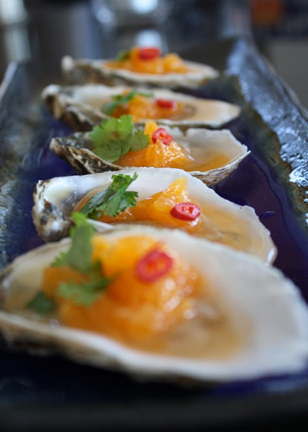 Fresh oysters plated with orange, chili and herbs from Benny Doro's kitchen