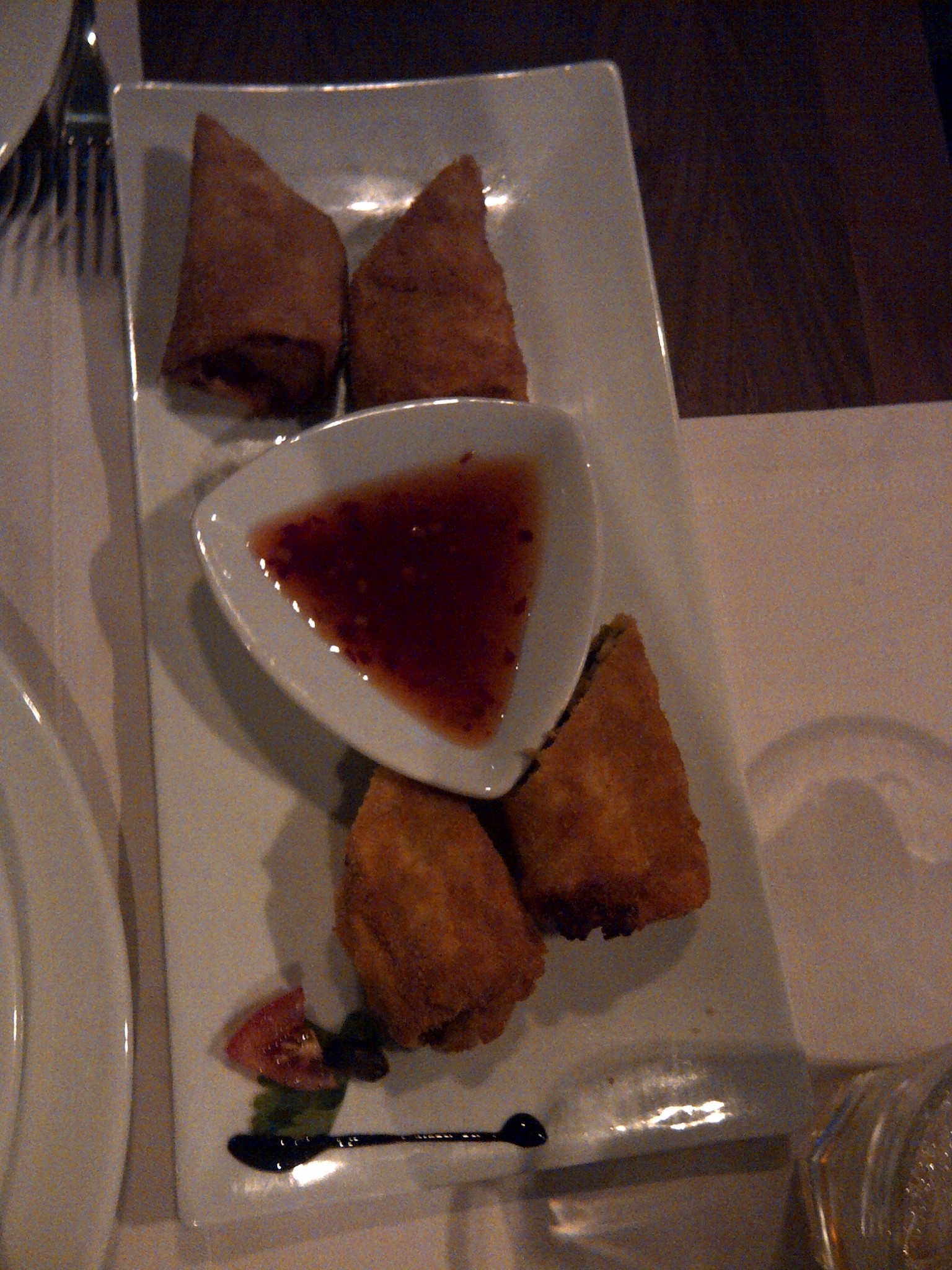 Fried pastries arranged around a bowl of red sauce