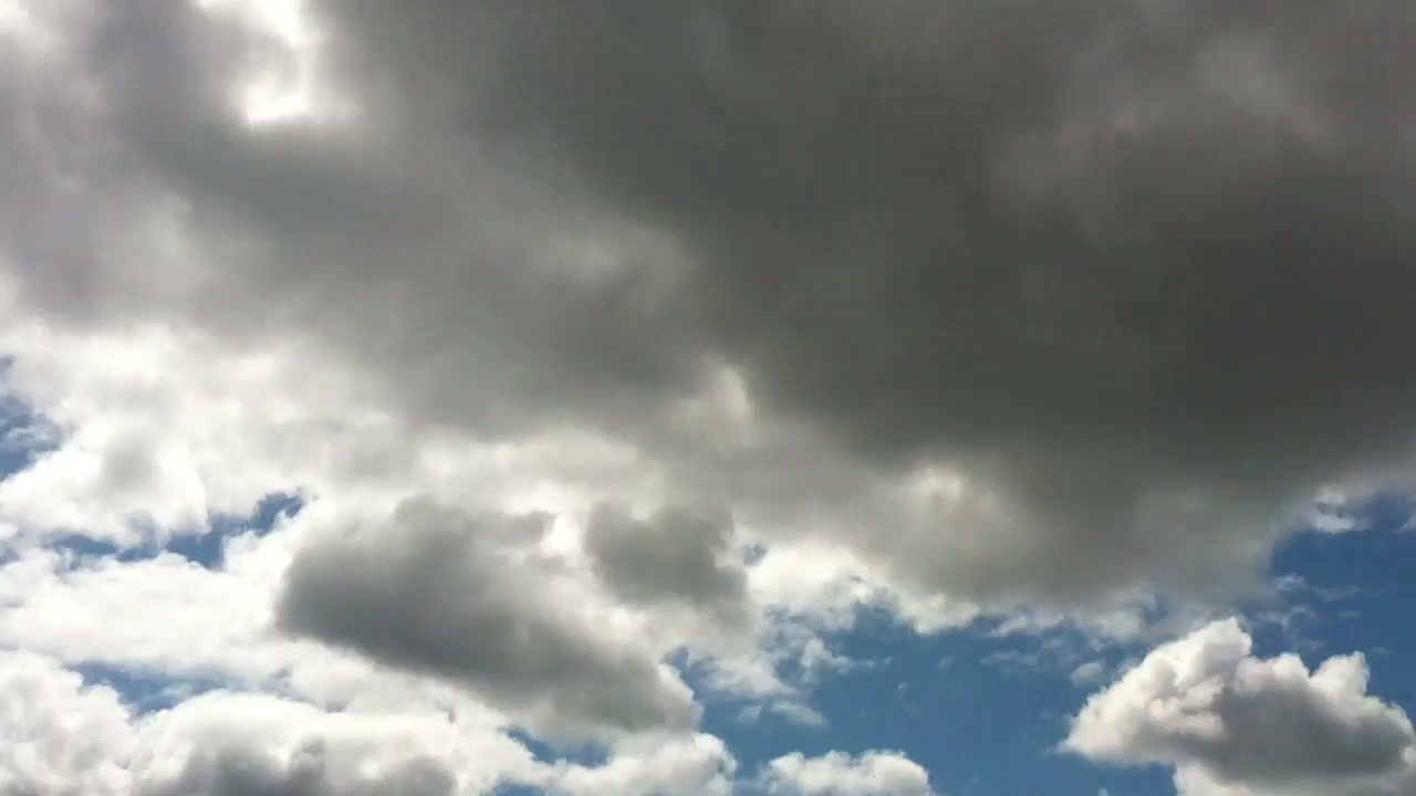 The shuttle carrier first appears as a distant dark shape beneath the clouds.