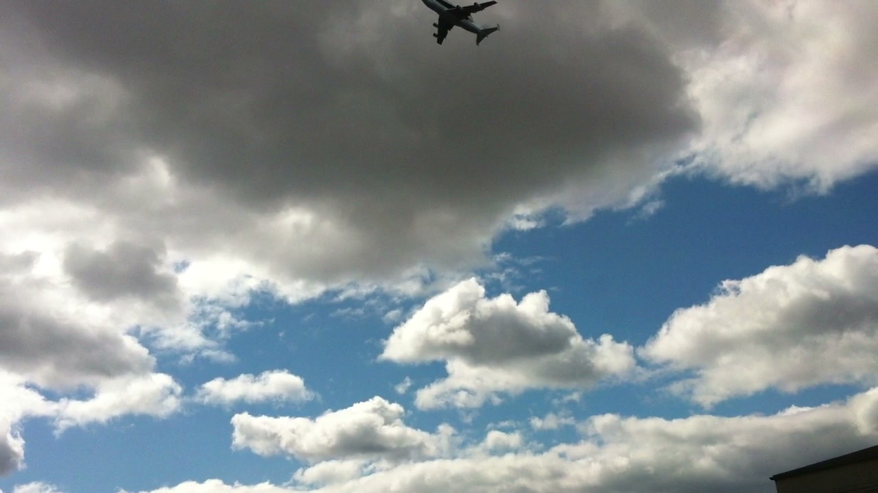 The NASA 747 and Space Shuttle Enterprise become recognizable against the clouds.