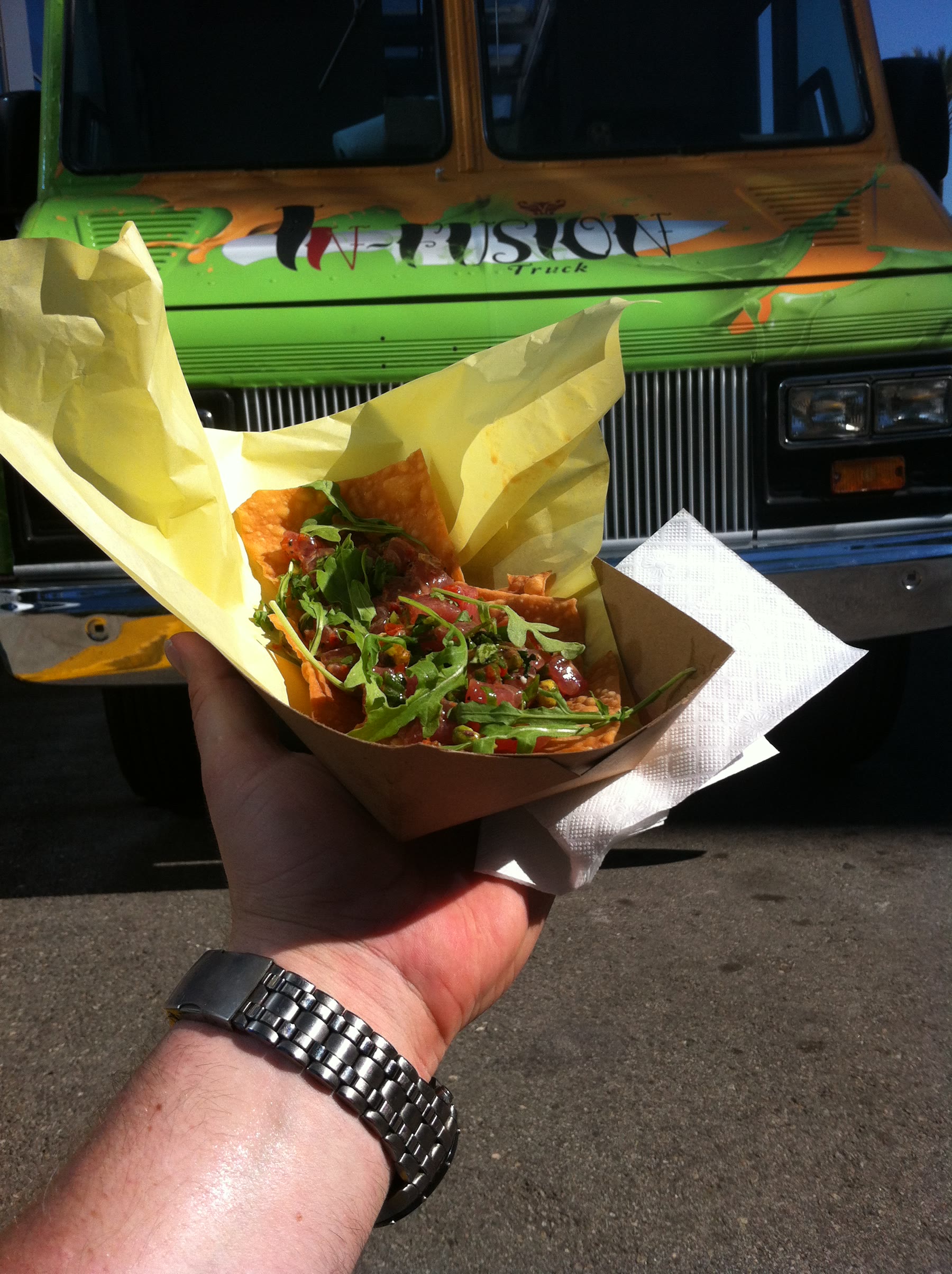 A serving of food held in front of the InFusion truck.
