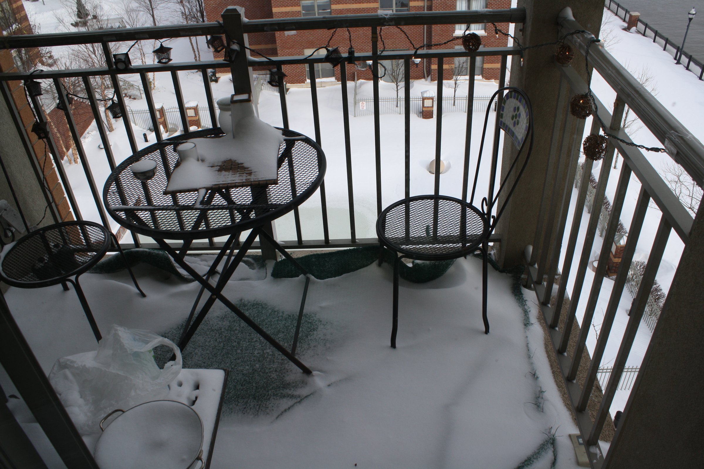 Balcony furniture surrounded by fresh snow.