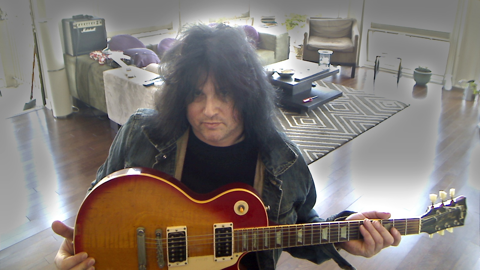 Benny Doro holding his Les Paul in his West New York apartment