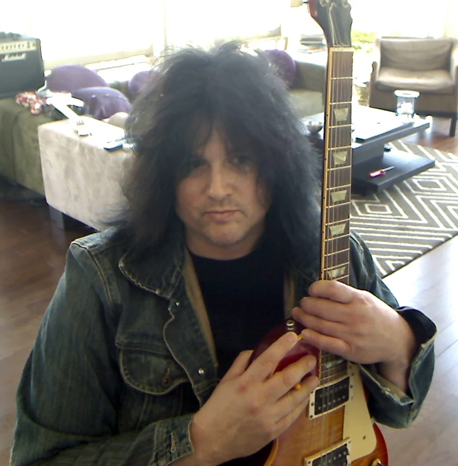 Benny Doro holding his Les Paul close to his chest.