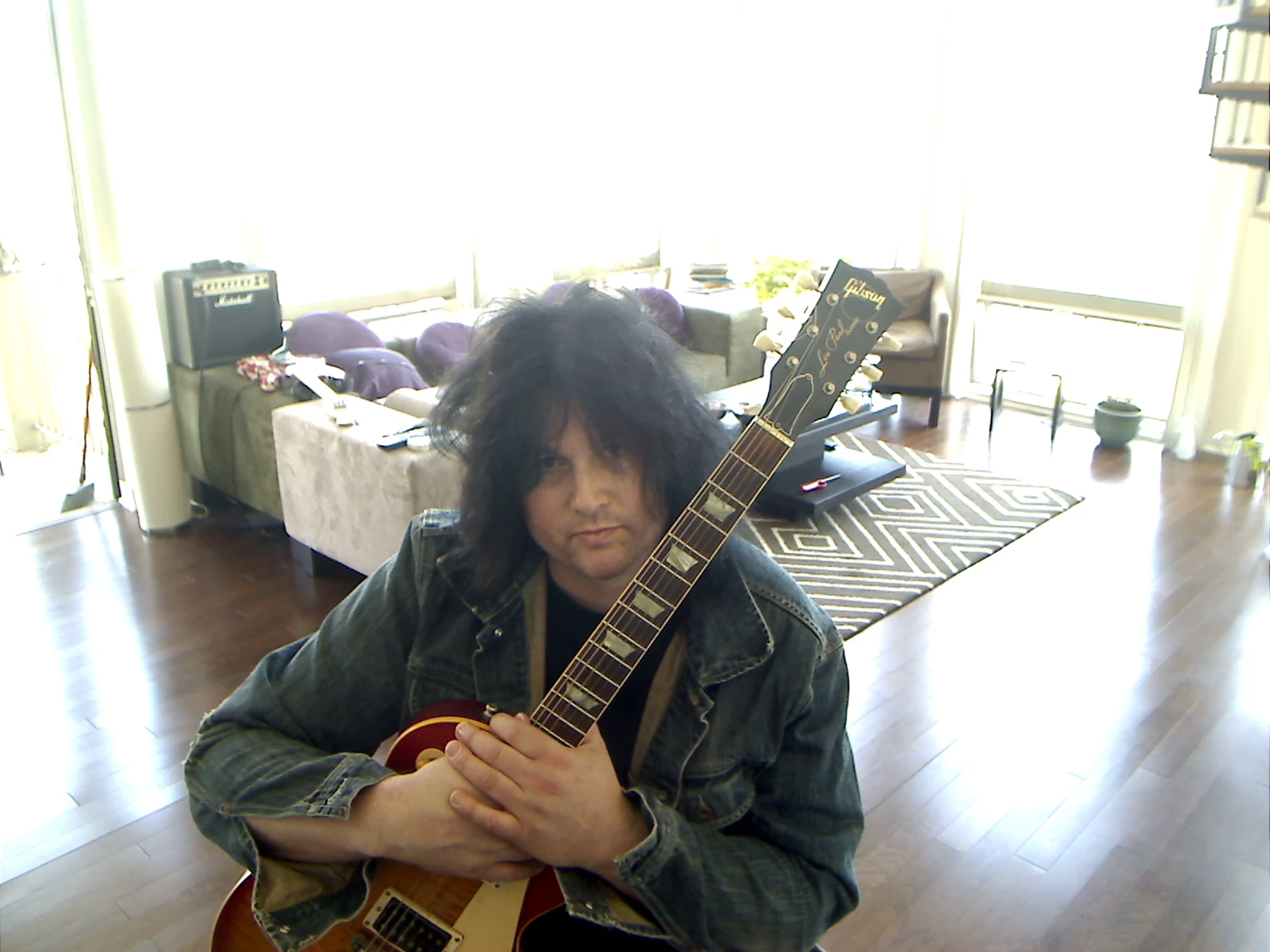 Benny Doro embracing his Les Paul in the apartment.