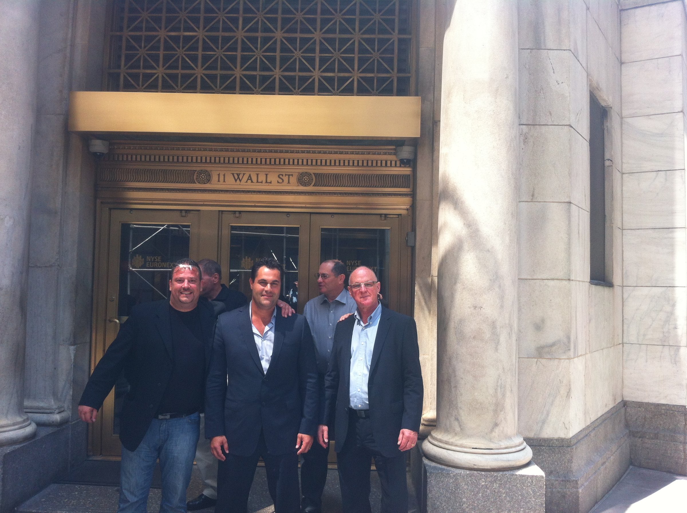 Four men outside the entrance marked 11 Wall Street.