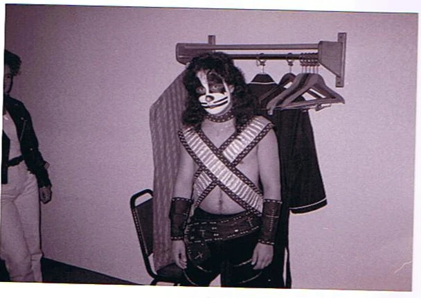A Black Diamond member in costume beside a hotel garment rack.