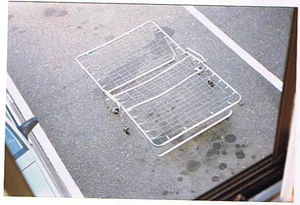 A broken metal equipment rack on the pavement.