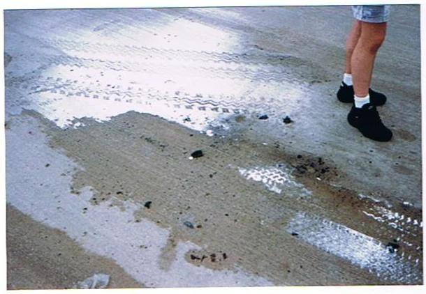 Wet tire tracks and road debris.