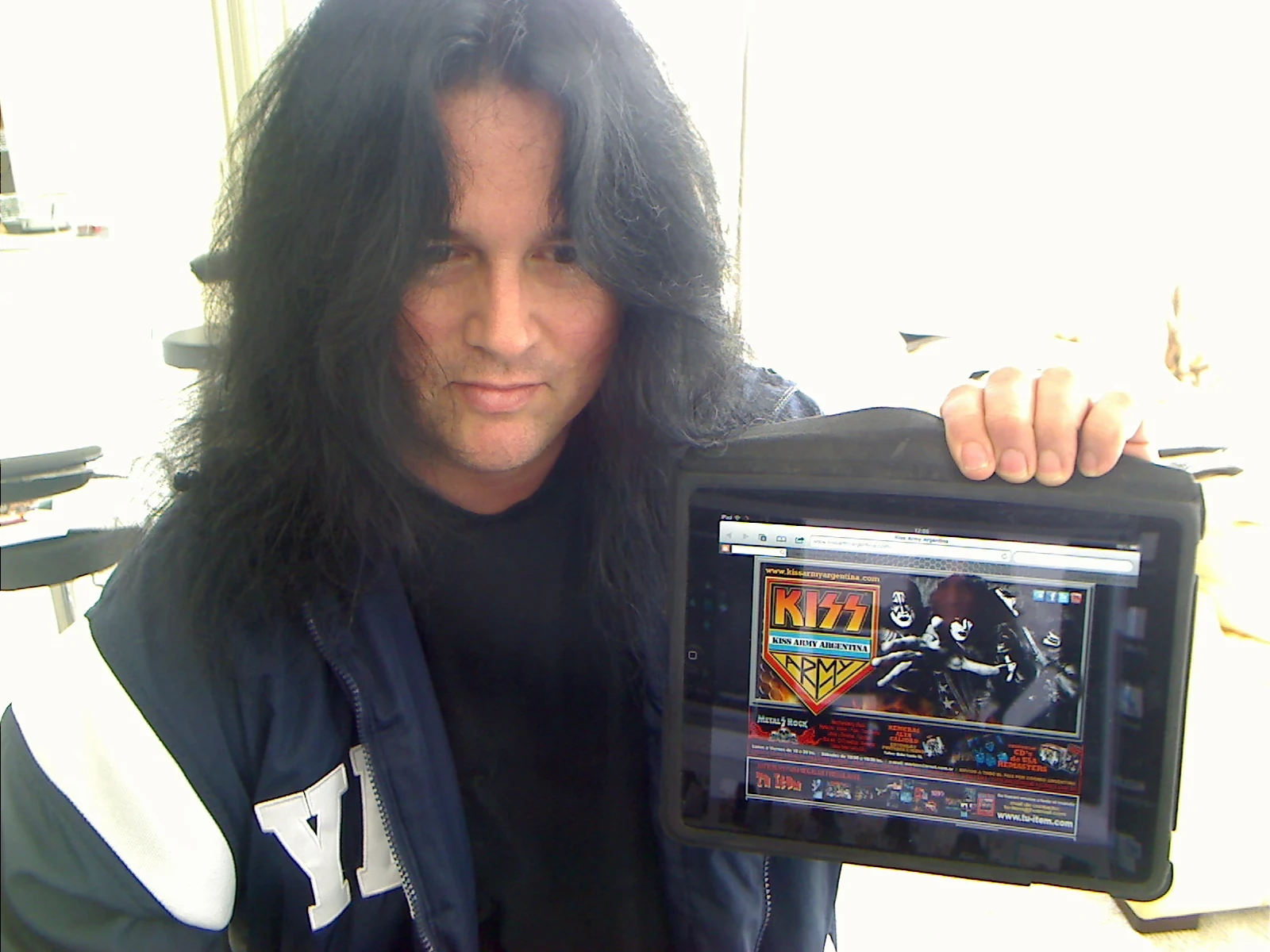 Benny holding an iPad with the KISS Army Argentina website.