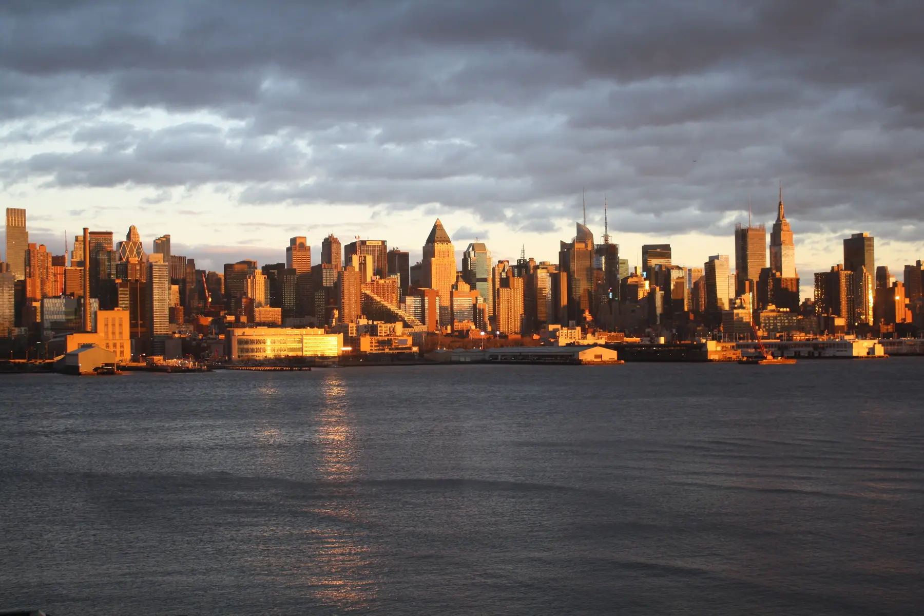 Midtown Manhattan glowing gold beneath a dramatic winter sky.