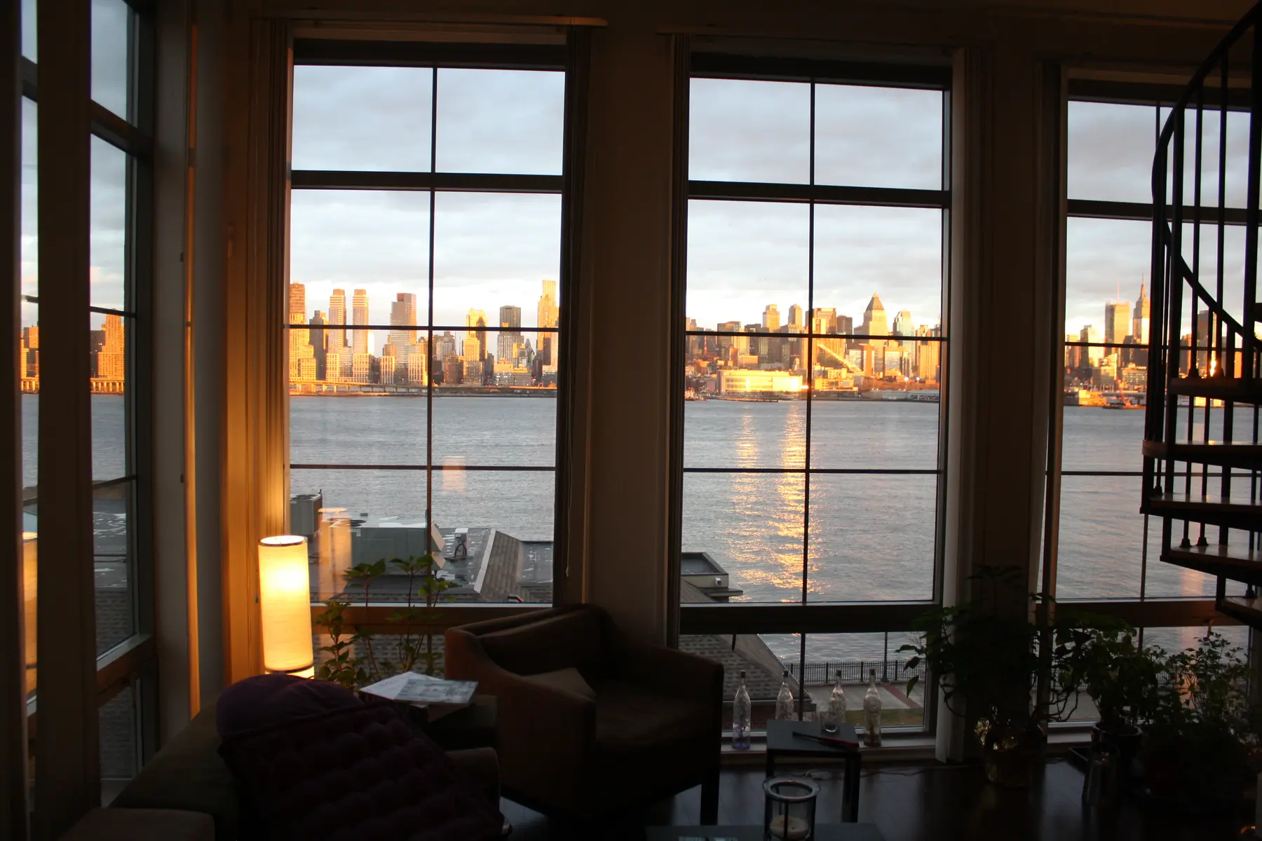 The apartment's warm living room with Manhattan framed through the windows.