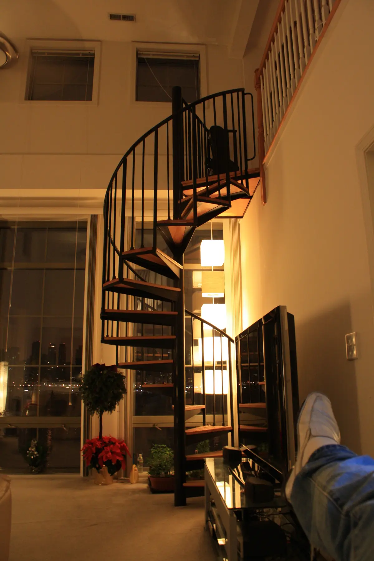 The spiral staircase and towering windows at night.