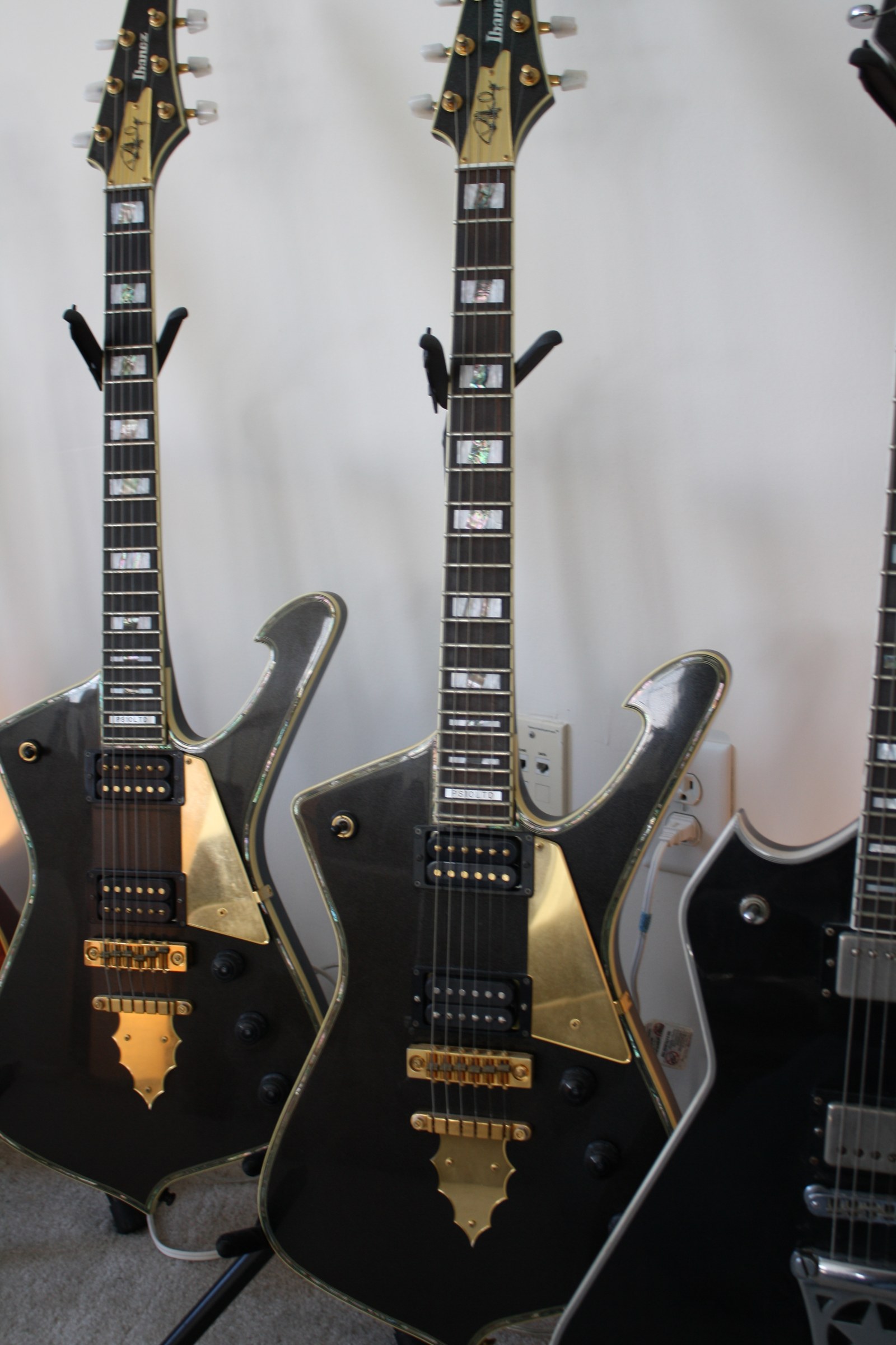 Two black angular Paul Stanley Iceman electric guitars.