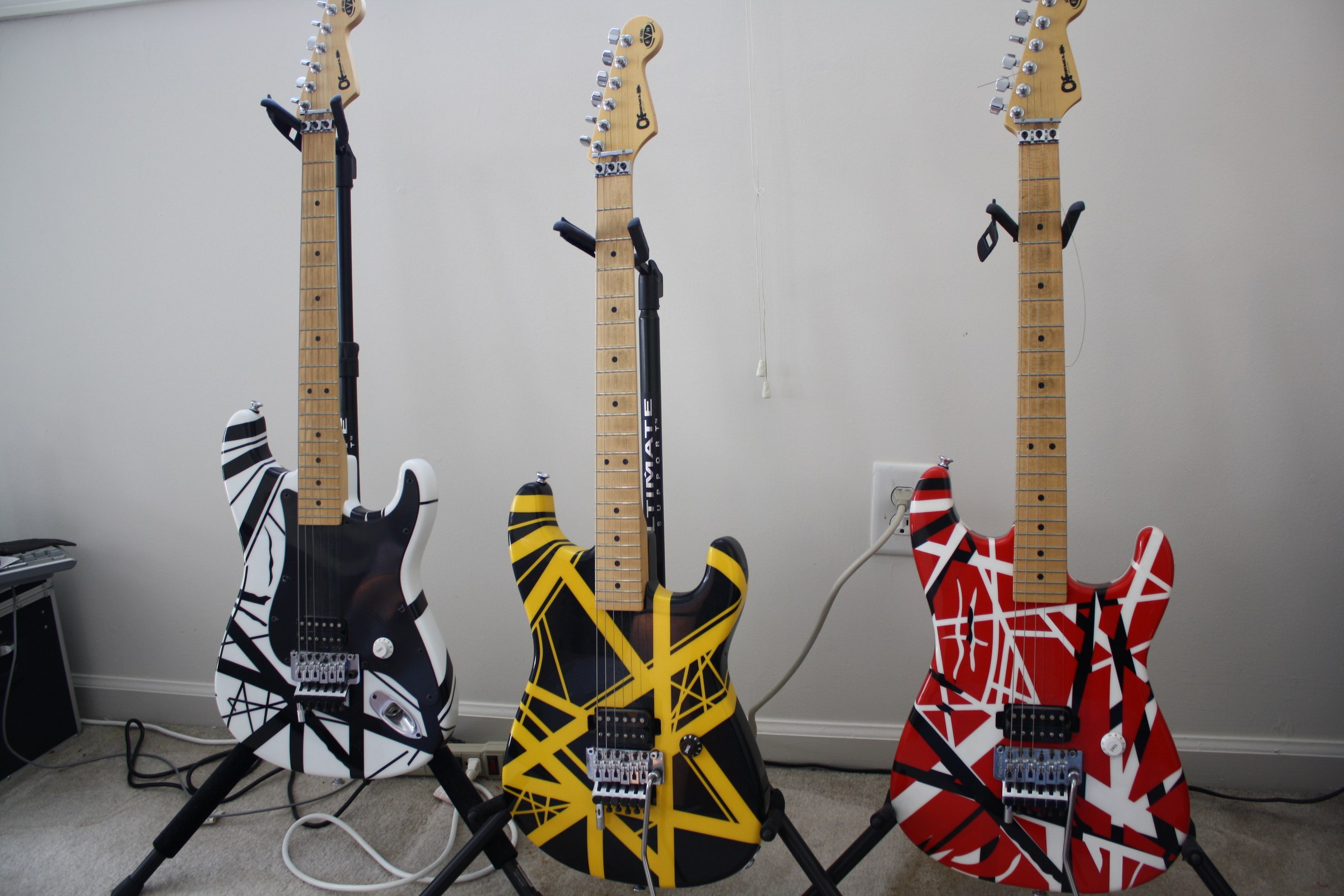 Black-and-white, yellow-and-black, and red-and-white striped electric guitars.