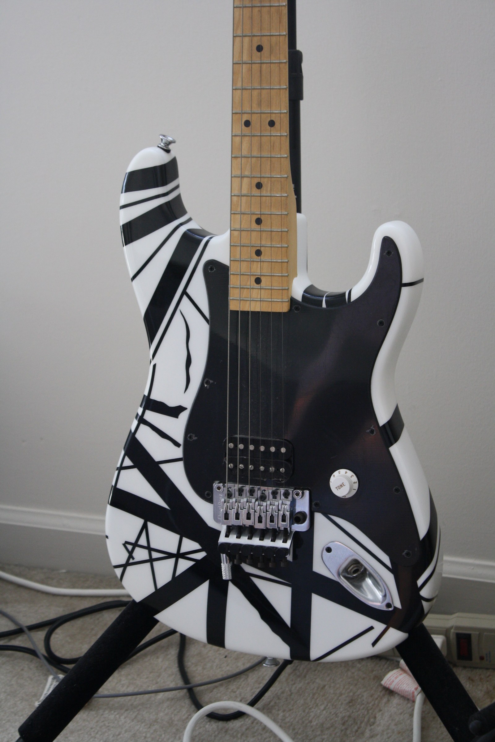 A black-and-white striped electric guitar with a pickguard.