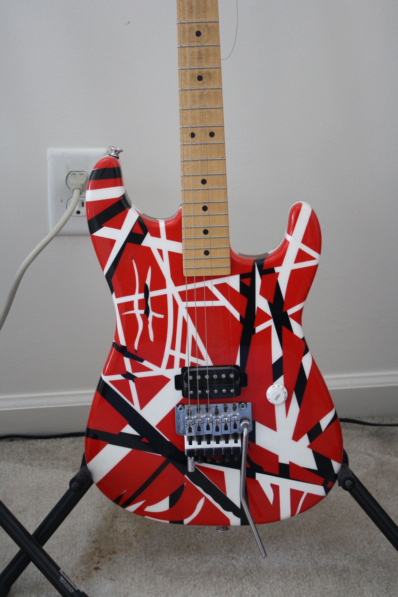 A red, white, and black striped electric guitar.